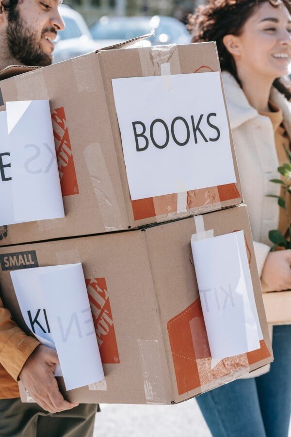 זוג סוחב ארגזים שעליהם כתוב "ספרים"