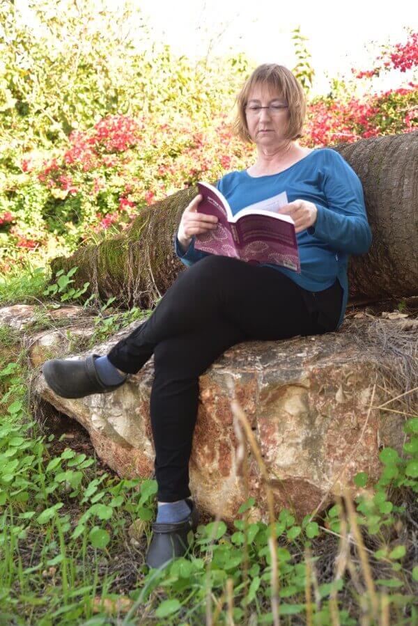 אישה יושבת וקוראת בטבע