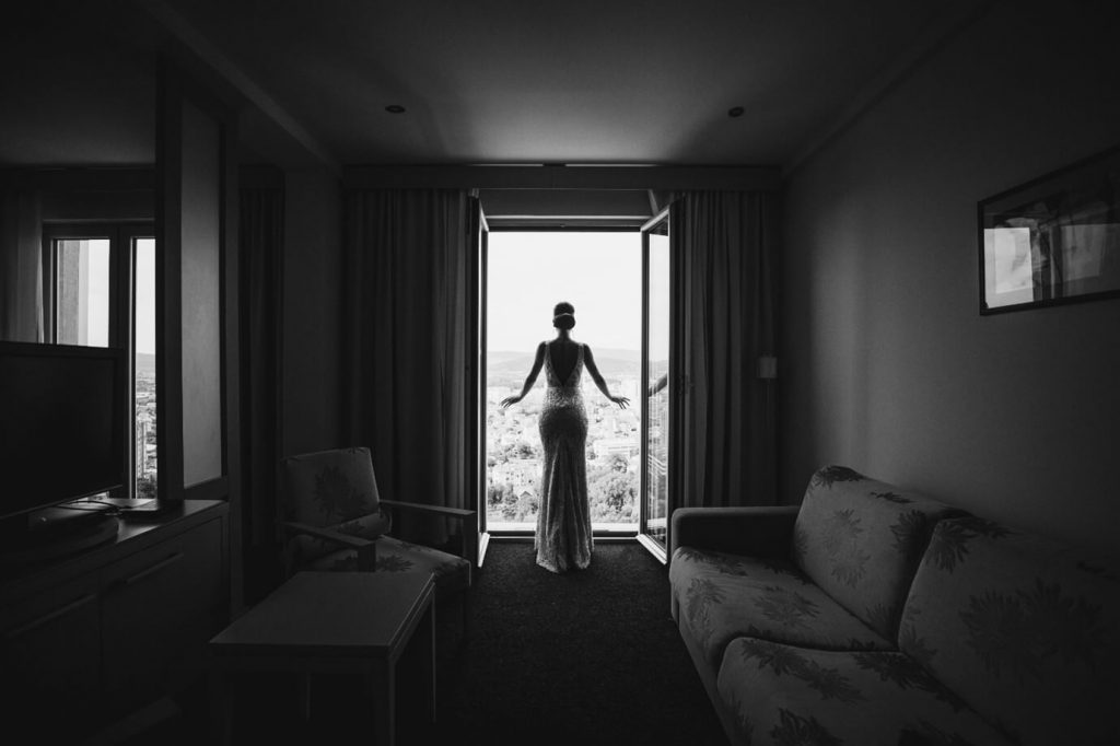 צילום של אישה המביטה מהסלון החוצה דרך חלון גדול